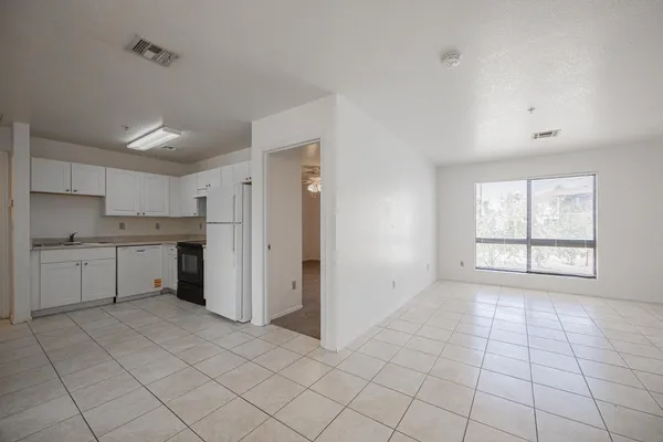 a view of a kitchen with white cabinets and a window