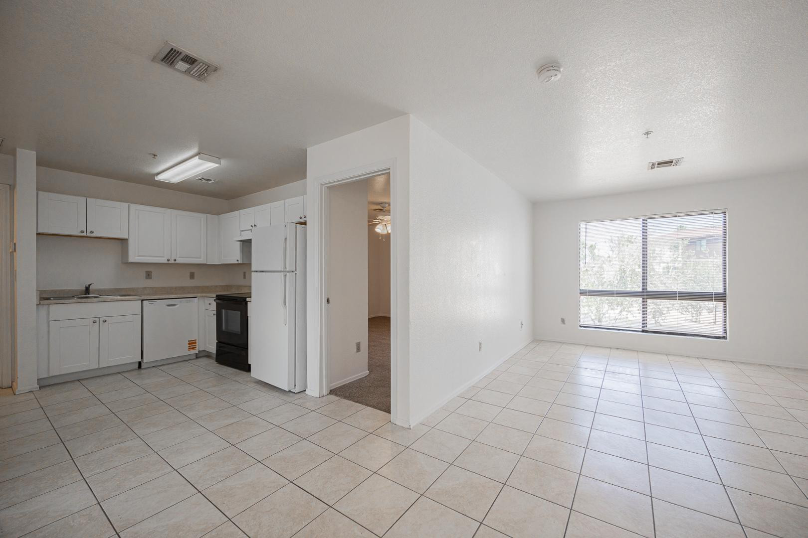 16033 North 25th Street, Unit 202 Phoenix, AZ 85032 - Photo 7 of 18 a view of a kitchen with white cabinets and a window