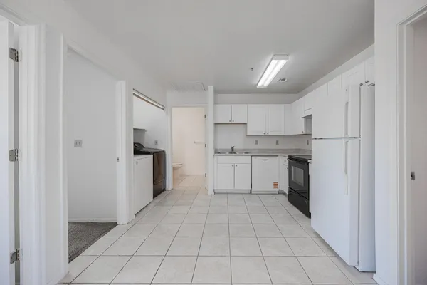 a kitchen with white cabinets a refrigerator stove and a sink