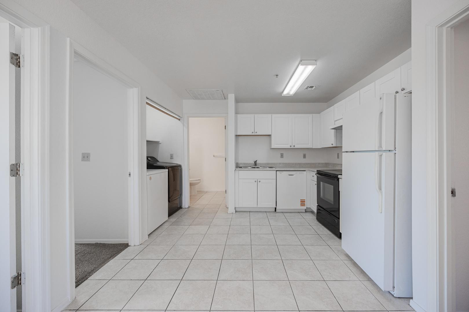 16033 North 25th Street, Unit 202 Phoenix, AZ 85032 - Photo 9 of 18 a kitchen with white cabinets a refrigerator stove and a sink