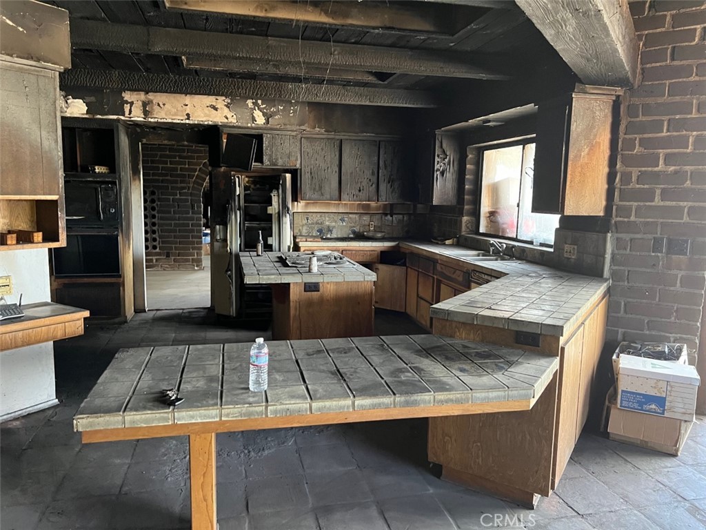 41220 Calle Contento Temecula, CA 92592 - Photo 15 of 30 a kitchen with kitchen island granite countertop a stove and a refrigerator