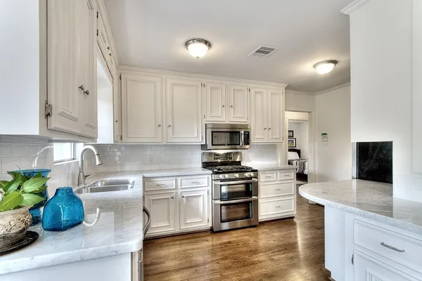 a kitchen with white cabinets and stainless steel appliances