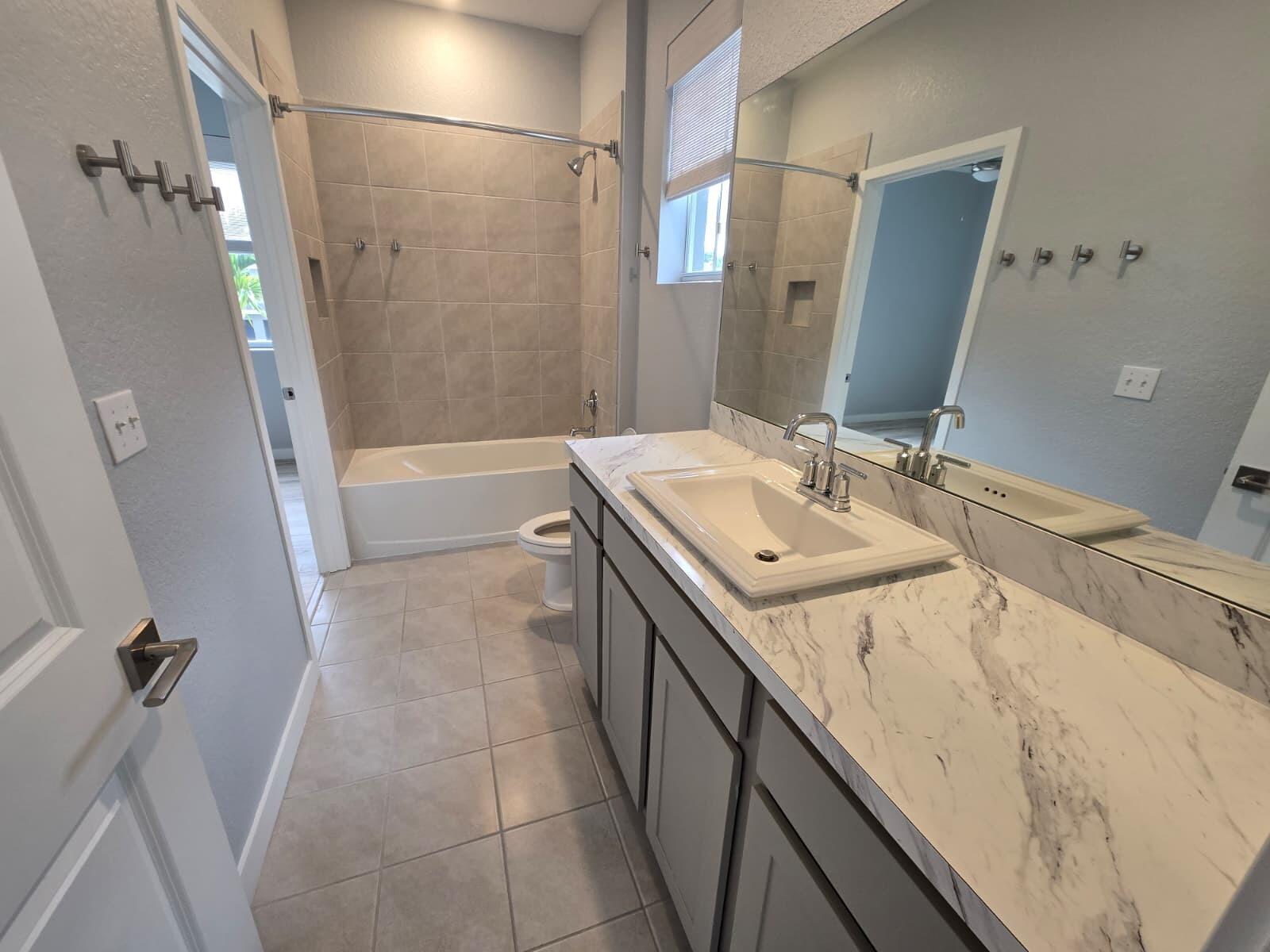 140 Bandol Street Riviera Beach, FL 33404 - Photo 25 of 42 a bathroom with a sink and mirror with bathtub