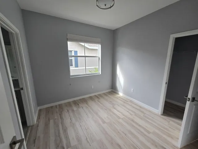 an empty room with wooden floor and a window