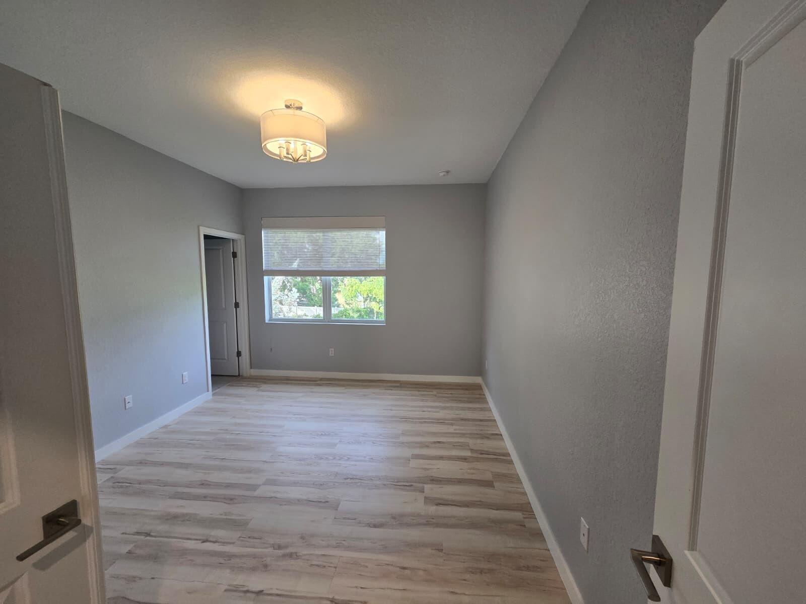 140 Bandol Street Riviera Beach, FL 33404 - Photo 35 of 42 an empty room with wooden floor and a window