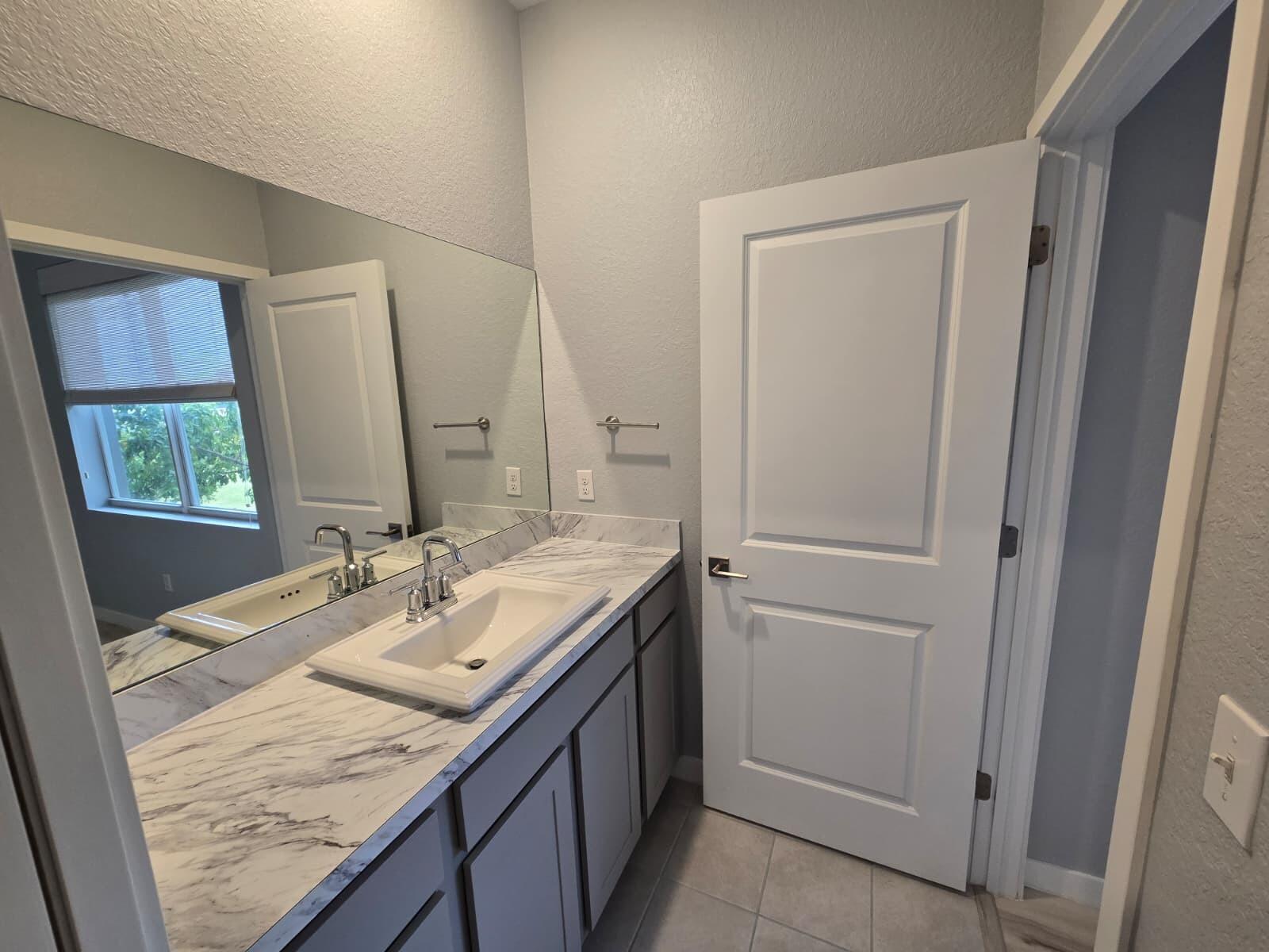 140 Bandol Street Riviera Beach, FL 33404 - Photo 38 of 42 a bathroom with a granite countertop sink and a mirror