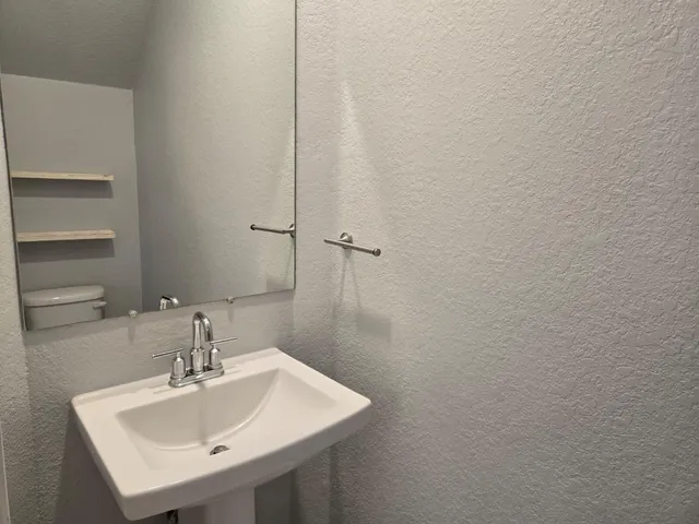 a bathroom with toilet sink and mirror