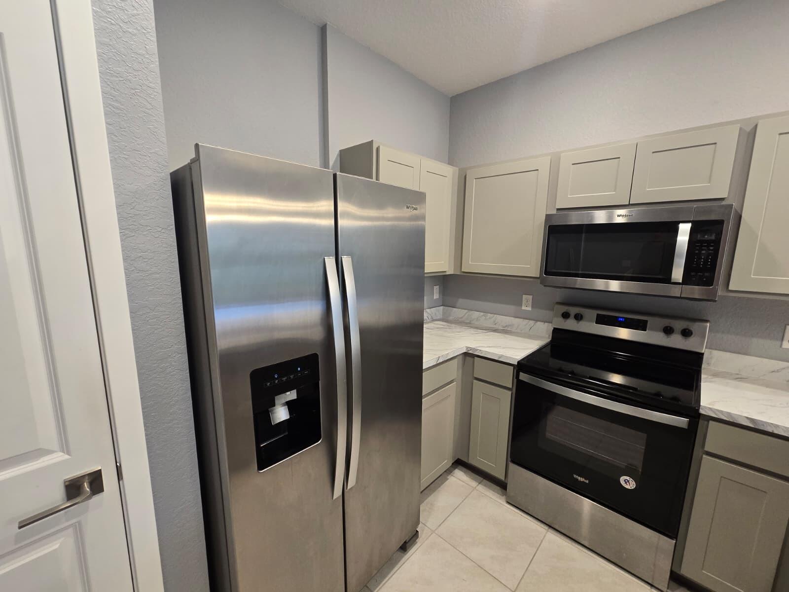 140 Bandol Street Riviera Beach, FL 33404 - Photo 10 of 42 a kitchen with a refrigerator stainless steel appliances and cabinets