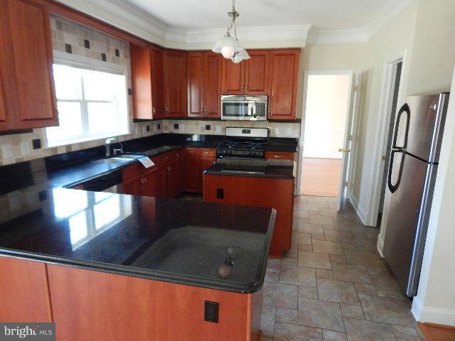 14813 Whitegate Road Silver Spring, MD 20905 - Photo 4 of 17 a kitchen with stainless steel appliances granite countertop a refrigerator a stove a sink and a window
