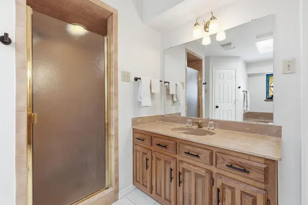 a large bathroom with a granite countertop double vanity sink a mirror and a shower