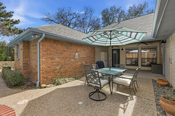 a view of a patio with table and chairs under an umbrella