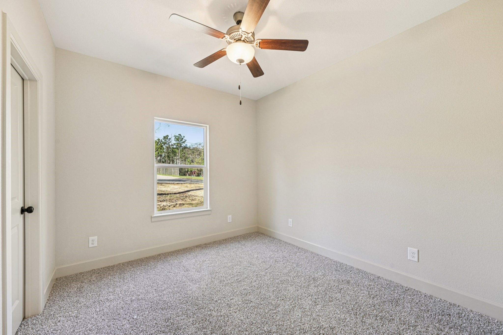 15132 Coaltown Road Willis, TX 77378 - Photo 16 of 29 Comfortable secondary bedroom with plush carpet flooring and a ceiling fan.