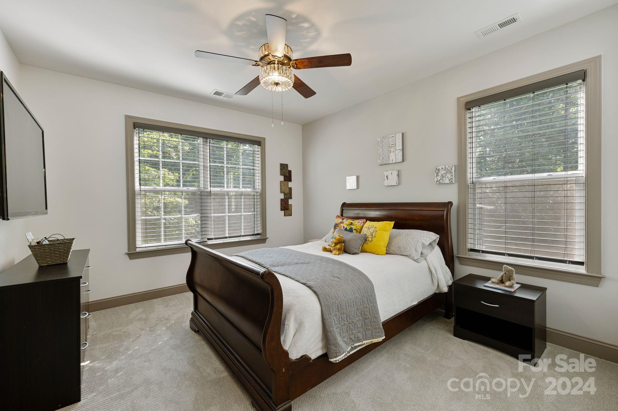 7086 Hawk Shadow Denver, NC 28037 - Photo 38 of 48 a bedroom with a bed and a chandelier
