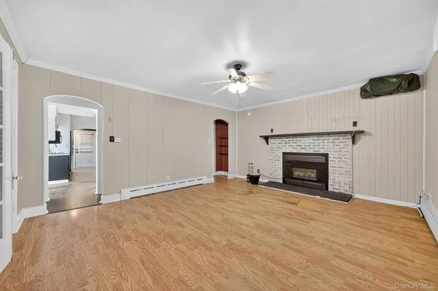 a view of an empty room with window and a fireplace