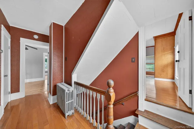 a view of a hallway with wooden floor and staircase