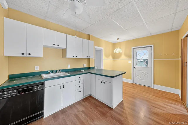 a kitchen with granite countertop white cabinets and stainless steel appliances