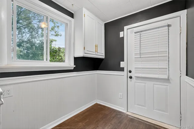a view of empty room with window and hardwood