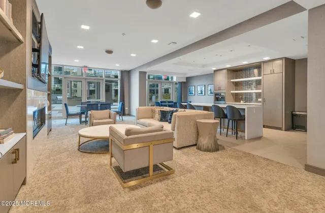 a living room with furniture a fireplace and a kitchen view
