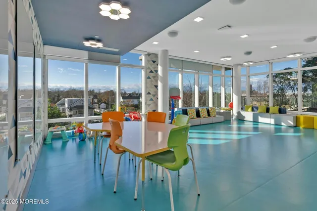 a dining room with furniture and a large window