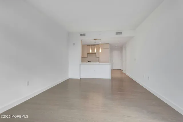 a view of an empty room with a kitchen