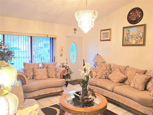 a living room with furniture and a chandelier