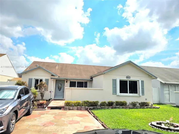 a front view of a house with a garden and yard