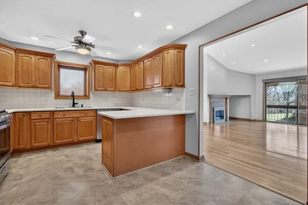 a kitchen with stainless steel appliances granite countertop a sink cabinets and wooden floor