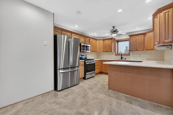 a kitchen with stainless steel appliances granite countertop a refrigerator a sink a stove a microwave and island