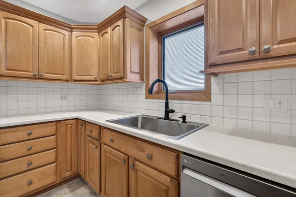 a kitchen with stainless steel appliances granite countertop a sink and a white cabinets