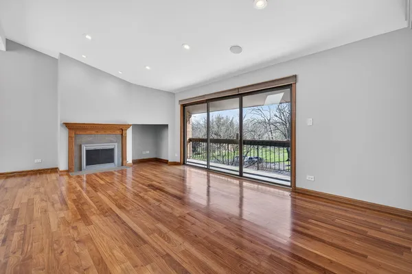 a view of empty room with wooden floor and fireplace