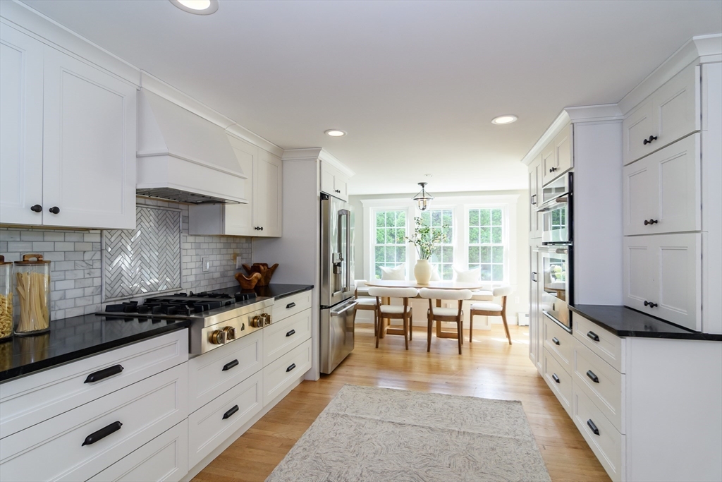 1 Roberts Road Wellesley, MA 02481 - Photo 7 of 29 a kitchen with granite countertop a stove a sink a dining table and chairs