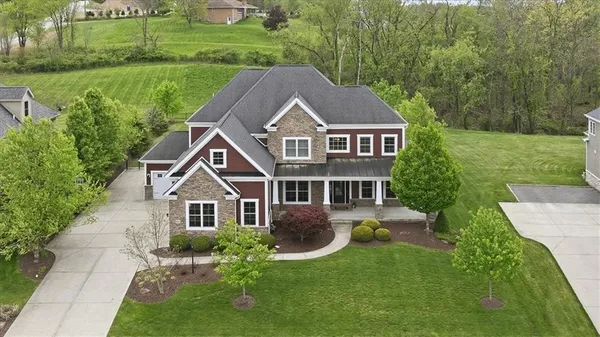a aerial view of a house next to a big yard and large trees