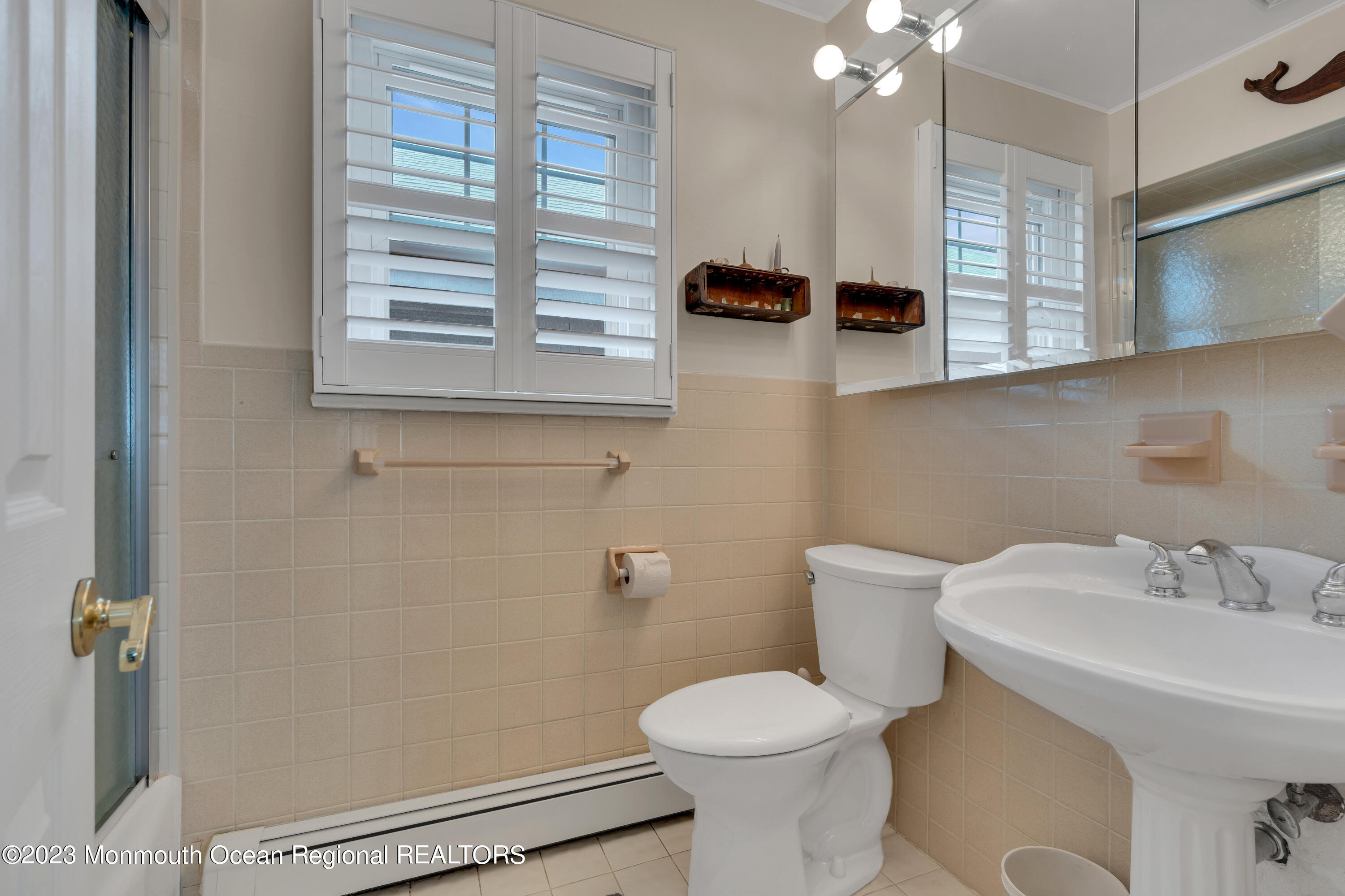 61 Beach Front Manasquan, NJ 08736 - Photo 11 of 20 a bathroom with a sink a toilet and a mirror