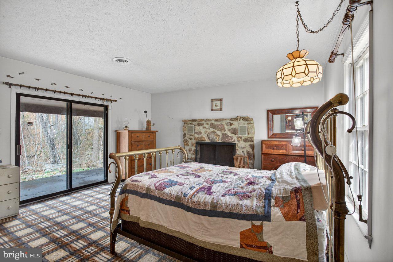 191 Hideaway Farms Road Edinburg, VA 22824 - Photo 27 of 40 a bedroom with a bed and a fireplace