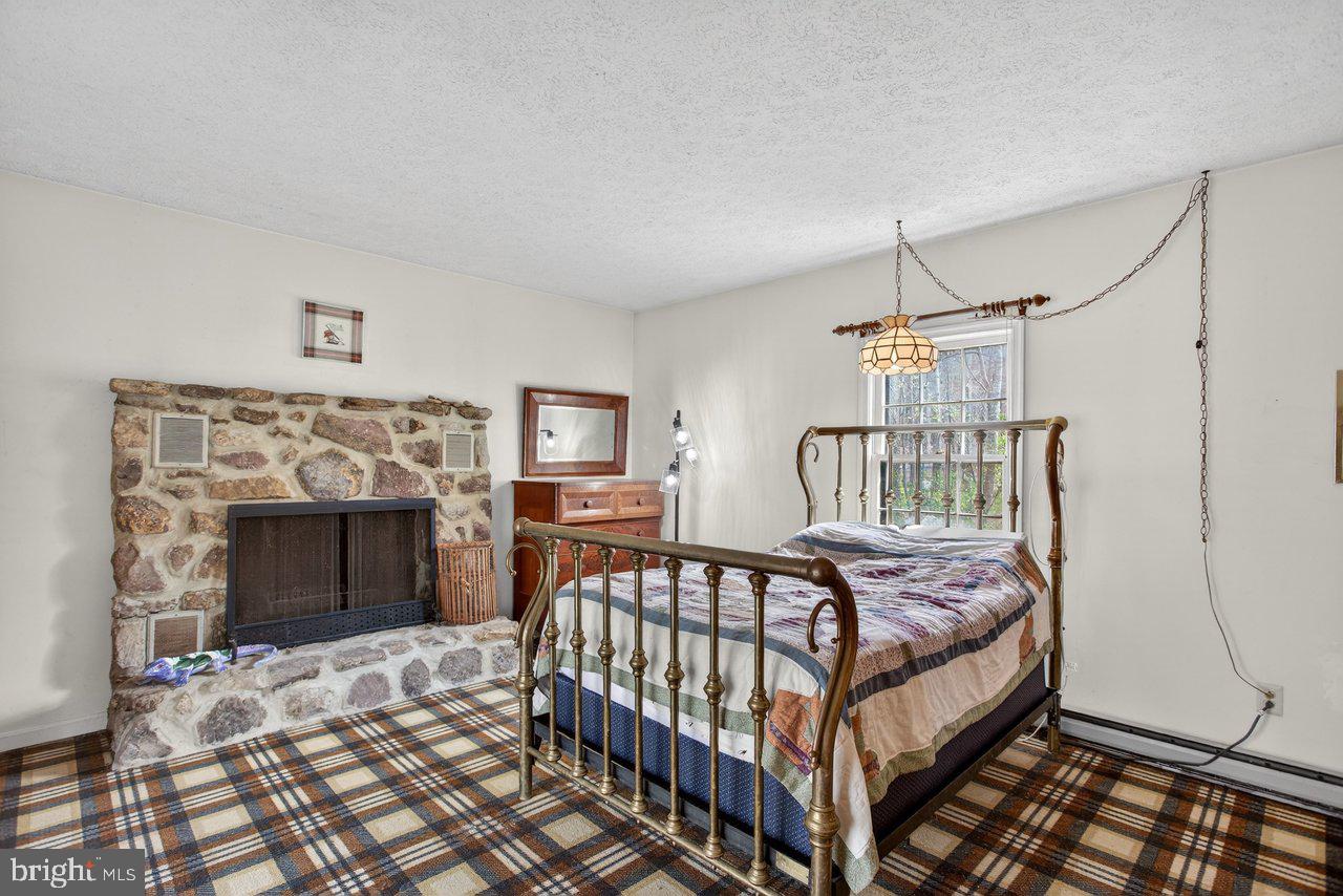 191 Hideaway Farms Road Edinburg, VA 22824 - Photo 28 of 40 a bedroom with a bed and a fireplace