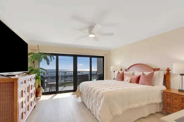 a bedroom with a large bed and a flat tv screen on dresser