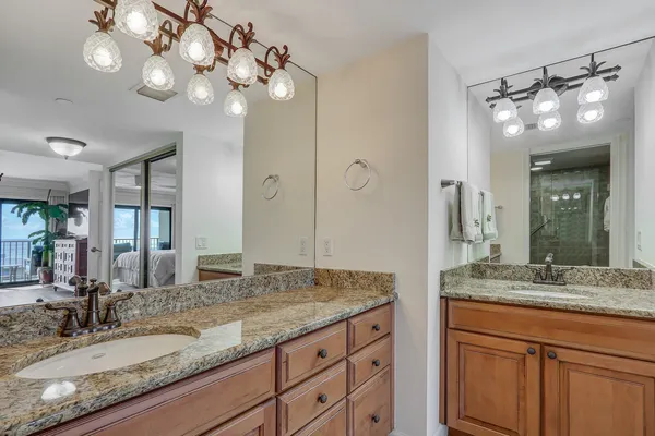 a bathroom with a granite countertop double vanity sink and a mirror