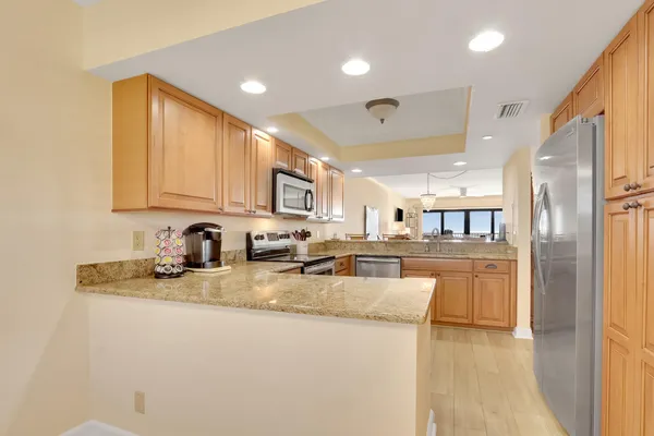 a kitchen with stainless steel appliances granite countertop a sink refrigerator and cabinets