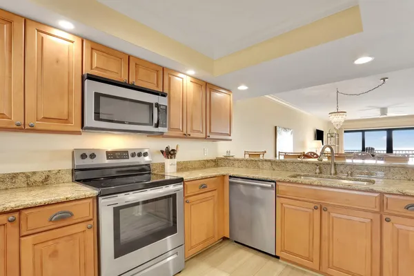 a kitchen with granite countertop a stove sink and microwave