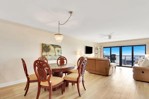 a dining room with furniture a chandelier and wooden floor
