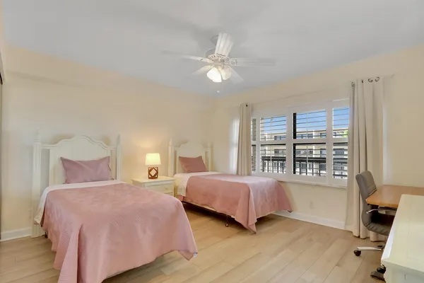 a bedroom with two beds and a large window