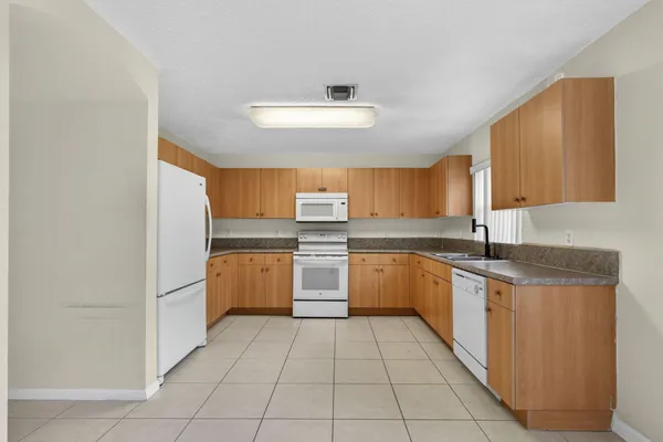 a view of a kitchen with refrigerator and white cabinets