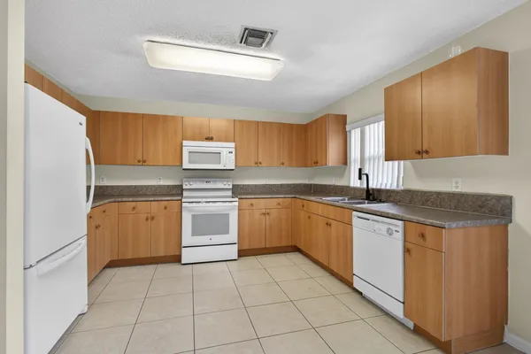a kitchen with a refrigerator sink and cabinets