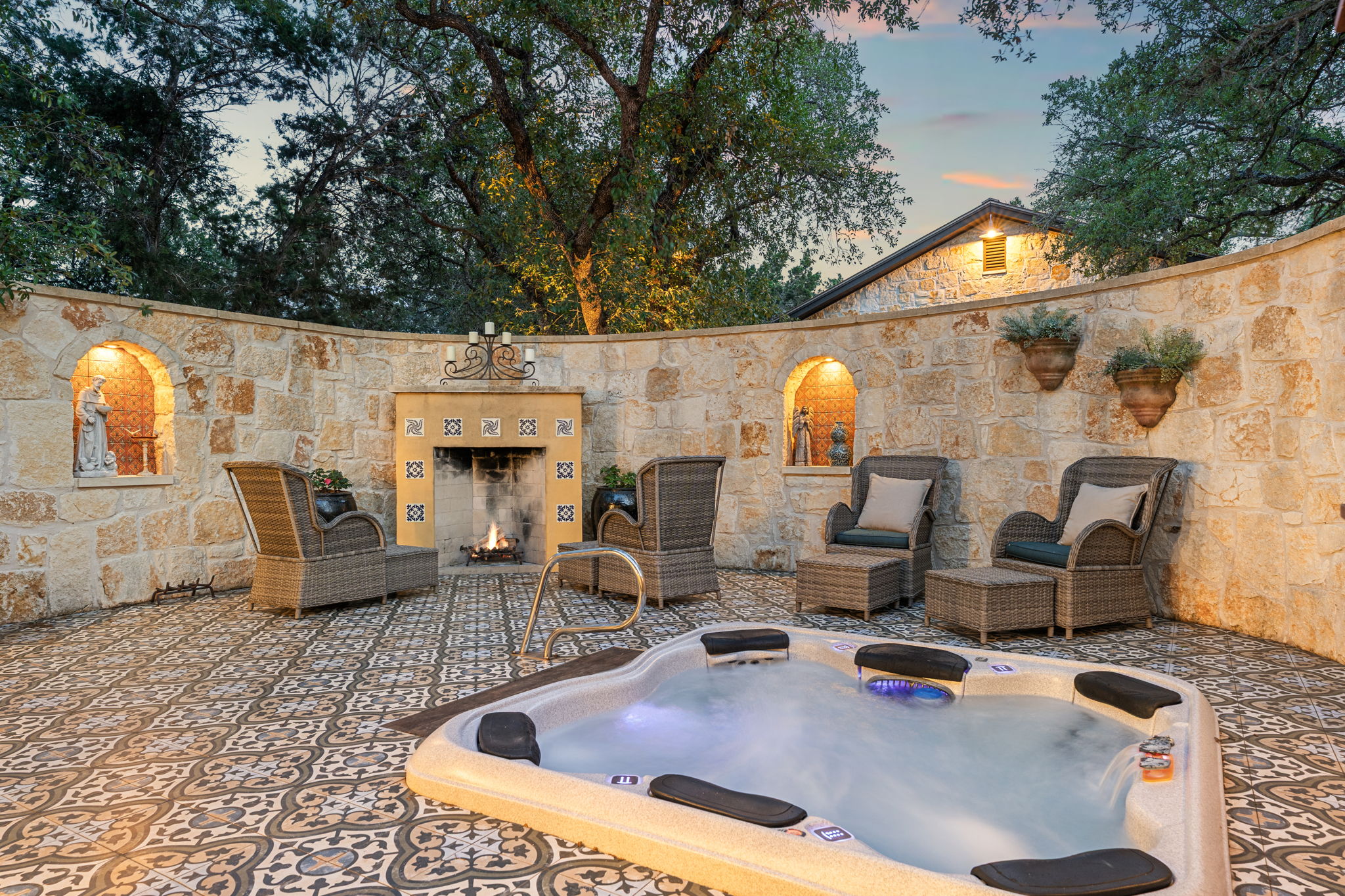 11941 Overlook Pass Austin, TX 78738 - Photo 18 of 40 private spa connected to the primary bath, featuring an integrated hot tub, stone privacy wall, and patterned tile flooring