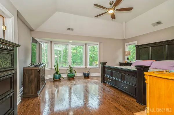 a view of a livingroom with furniture hardwood floor a ceiling fan and a fireplace