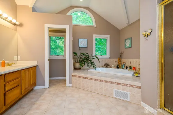 a bathroom with a tub sink and mirror