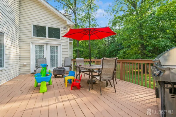 a view of a deck with furniture and barbeque grill with wooden floor