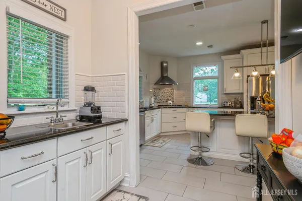 a kitchen with white cabinets and window