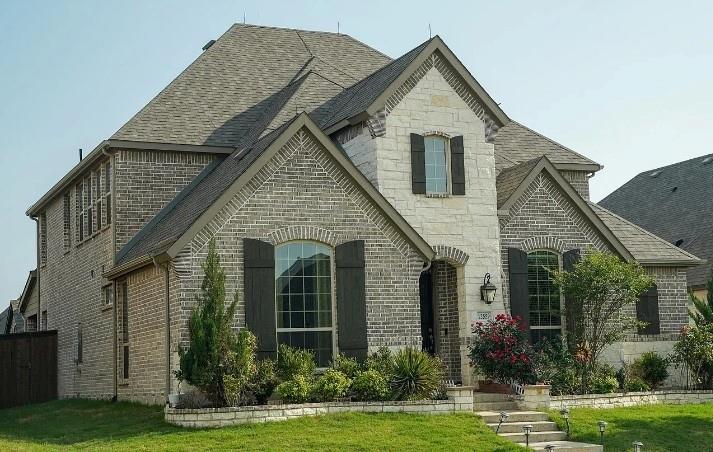 12559 Ravine Creek Road Frisco, TX 75035 - Photo 2 of 33 French country inspired facade with a shingled roof, brick siding, and a front yard