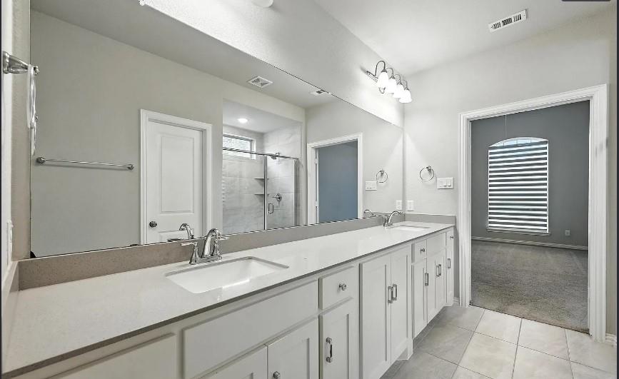 12559 Ravine Creek Road Frisco, TX 75035 - Photo 21 of 33 Bathroom with double vanity, a shower stall, light carpet, and light tile patterned flooring